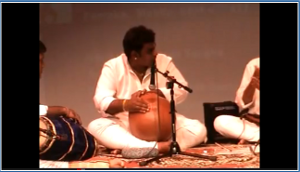 Sitting musician playing the ghatam.