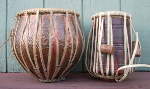A tabla dayan and tabla bayan with ripped pudis and strap.